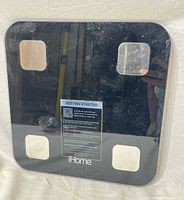 Top view of iHome Smart Scale showing glass surface, sensor pads, logo
