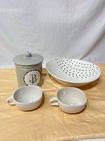 Group shot of serving bowl, two soup bowls, and canister with lid