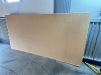 Front view of one beige acoustic panel leaning against wall