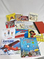 Group of fourteen children’s books arranged on white backdrop showing covers