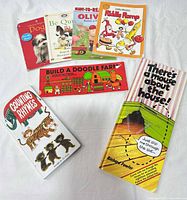Seven children’s books laid out including Dogs, Be Quiet Mike!, Olivia, Riddle Romp, Build a Doodle Farm, Counting Rhymes, There’s a Mouse About the House!
