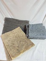 Gray textured rug, beige rug, folded gray felt pad