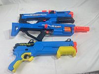 Three toy blasters laid side by side showing full condition and branding