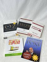 Five hardcover books laid out showing covers