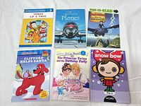 Six assorted children’s books laid out on white surface
