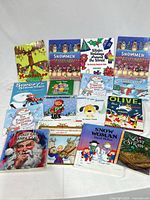 Front view of all sixteen children’s Christmas and winter books in the lot