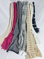 All seven scarves hung to show colors, patterns, materials and fringe details