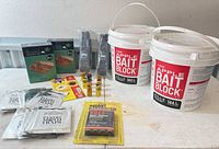 Overall lot showing two bait block pails, moth trap packs, gas cartridges, plastic traps, fly sticker traps, cedar log boxes