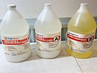 Three 1-gallon Magic Resin containers, two clear Part A and one yellow Part B