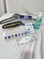 Overview of face shields, sanitizer bottle, pill organizer, N95 mask, and boxed stapler