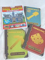 All four Minecraft guidebooks front covers visible