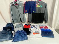 All items laid out: jackets, soccer shorts, jeans, shorts, T-shirts
