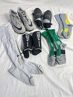 All items laid out: cleats, two shin guard pairs, three sock pairs