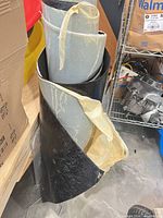 Roll standing upright showing black granular outer surface and release sheet