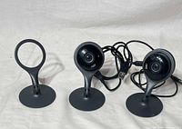 Two Nest Cam Indoor cameras with attached stands and USB cables plus spare stand