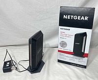 Modem on stand with power adapter and box