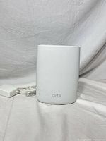 Front view of Orbi router with power adapter
