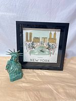 Framed New York print and Statue of Liberty figurine together