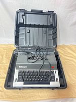 Olympia electric typewriter inside open hard case with power cord