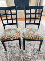 Front view of both dining chairs showing lattice backs and floral seats