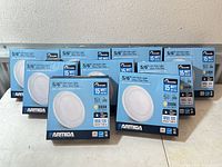 Eight boxed Parmida LED disk lights displayed