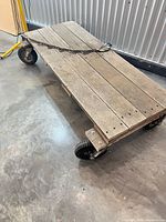 Full view of wooden platform dolly cart showing deck and wheels