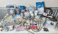 Overall lot showing faucet, hoses, pump box, fittings