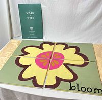 Front view of four panels assembled, flower graphic, and A Word A Week posters behind