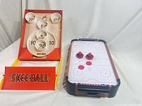 Skee-Ball game and air hockey board with accessories displayed