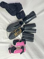 All items laid out: cleats, black shin guards, pink shin guards, socks, inserts