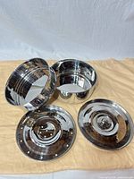 All four stainless steel pieces: two pots, perforated tray, lid