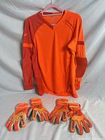 Full view jersey on hanger with gloves laid below