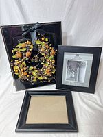 Welcome sign, picture frame, additional frame parts on white backdrop