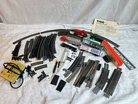 Overview of entire lot: locomotive, six cars, transformer, bridge, track pieces, instructions