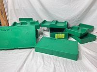 Multiple green United States Mint coin trays showing quantity and condition