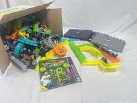 Box with assorted Vortex marble run plastic track pieces and instruction manual