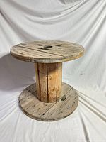 Full view of repurposed wooden cable spool table showing top, base and central drum
