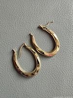 Both yellow gold teardrop hoop earrings front view