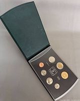 Open specimen set in green case showing seven coins in holder
