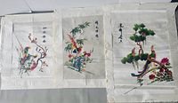 Three silk embroidery panels side by side showing overall designs and condition