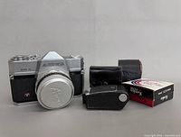 Front view of Aires Penta 35 camera with cap, Vivitar lens case, light meter, Kenko filter box