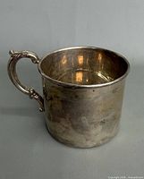 Side view of sterling silver baby cup, showing overall form and handle