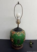 Full view of lamp without shade showing bulb, harp and base