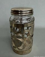 Full view of glass spice jar with silver overlay and lid