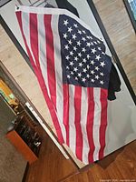 Full view United States flag hanging, showing stripes and star field