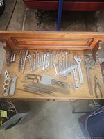 overview of assorted tools arranged on wooden surface