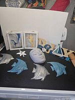 Full lot overview showing four metal fish, starfish hook, face wall pocket, Relax sign, two framed prints