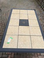 Top view of rectangular tile-top patio table showing tan ceramic tiles and umbrella hole