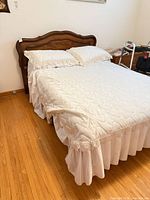 Front view of assembled bed showing wood headboard and mattress