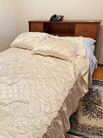 Full bed with quilted cover, view of headboard drawers